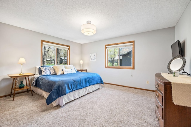 bedroom with light carpet, multiple windows, baseboards, and a textured ceiling