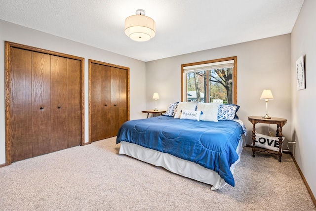 bedroom featuring carpet and multiple closets