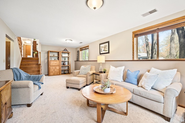 living area featuring stairway and carpet floors
