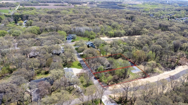 aerial view of property and surrounding area featuring a heavily wooded area and property boundaries highlighted