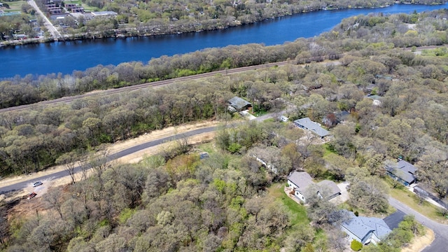 aerial overview of property's location featuring a nearby body of water and a heavily wooded area