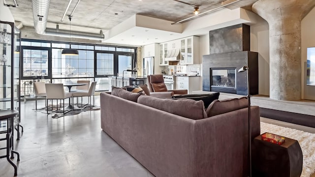 living room featuring a tile fireplace and finished concrete floors