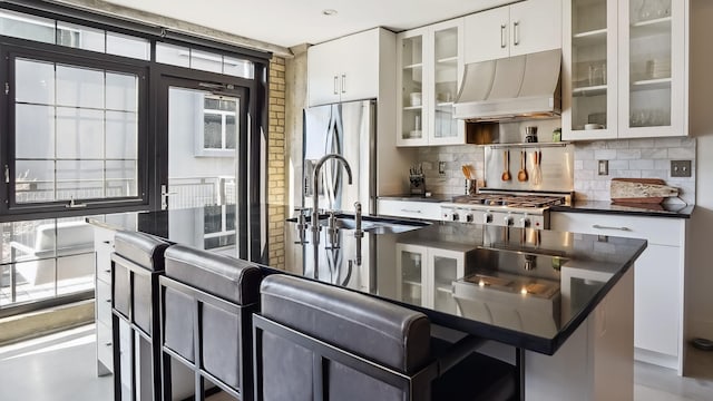 kitchen with dark countertops, freestanding refrigerator, a sink, range, and extractor fan