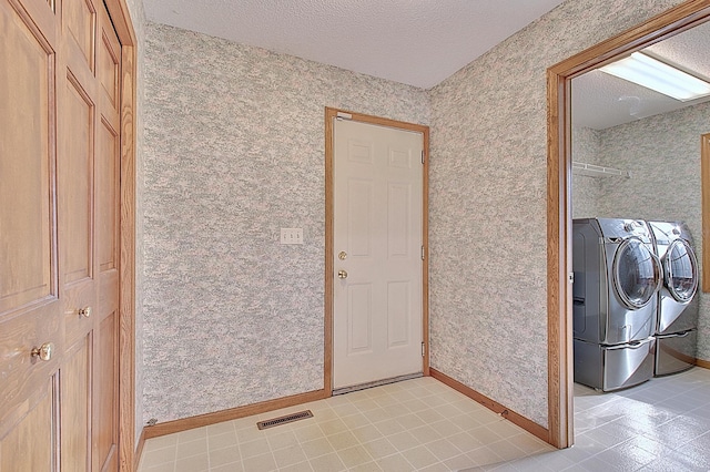 washroom featuring laundry area, washer and clothes dryer, visible vents, and wallpapered walls