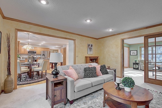 living area with ornamental molding, french doors, a textured ceiling, and light colored carpet