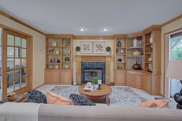 living area with built in shelves, a fireplace, crown molding, and baseboards