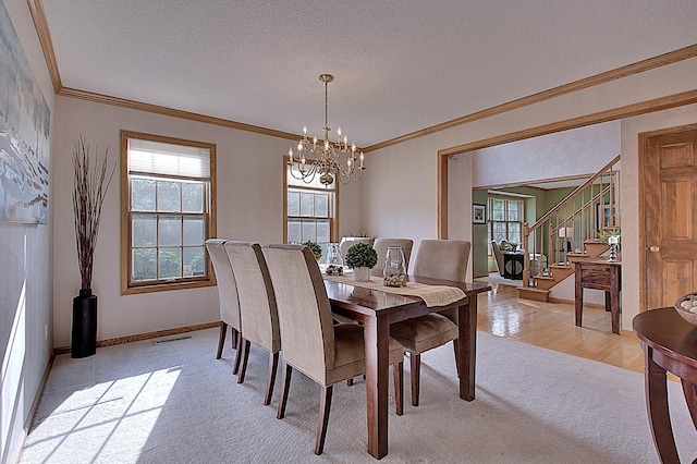 dining area featuring stairway, ornamental molding, and a textured ceiling