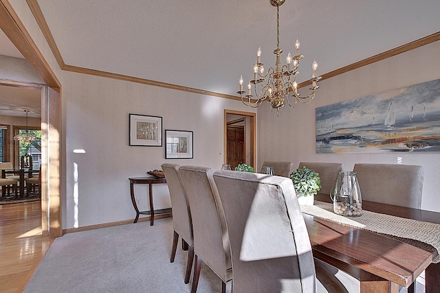 dining room featuring a notable chandelier, a textured ceiling, baseboards, and crown molding