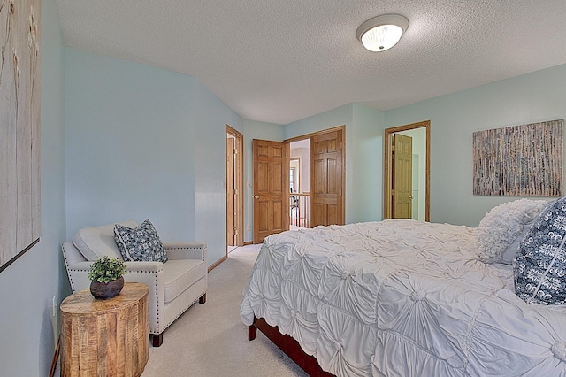 bedroom featuring a textured ceiling, a closet, and light colored carpet