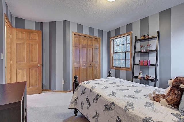 bedroom with light carpet, wallpapered walls, baseboards, a textured ceiling, and a closet