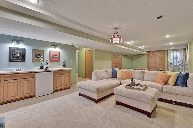 living area featuring light carpet, recessed lighting, indoor wet bar, and a textured ceiling