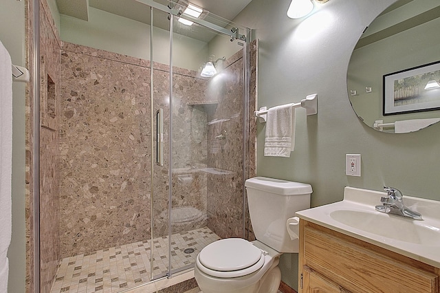 full bath featuring vanity, a shower stall, and toilet