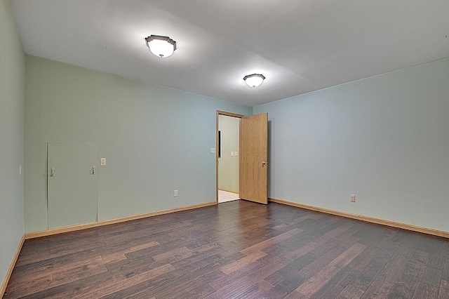 spare room with dark wood finished floors and baseboards