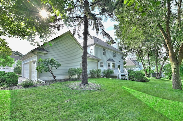 view of side of home featuring an attached garage and a lawn