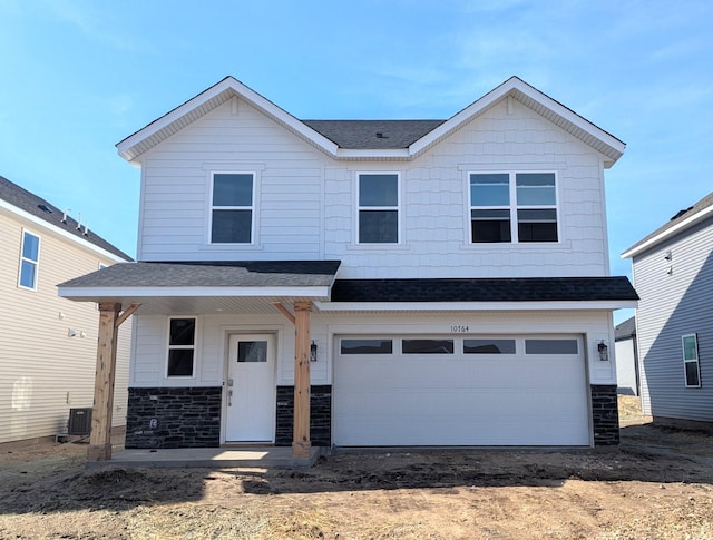 view of front of house featuring a garage, stone siding, cooling unit, and a shingled roof