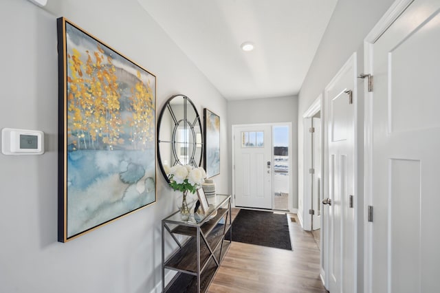 doorway featuring baseboards and wood finished floors