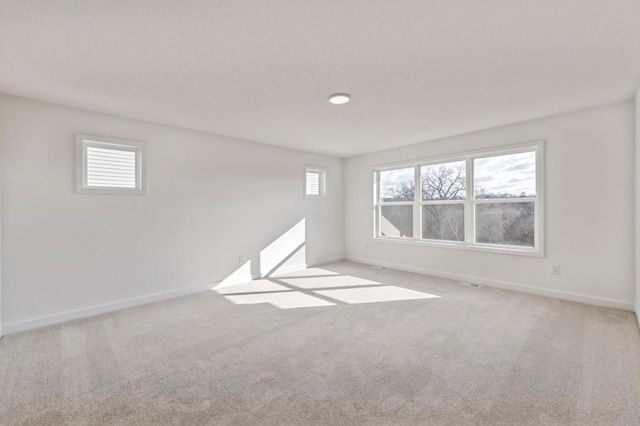 unfurnished room with carpet and baseboards