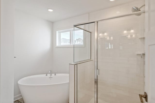 bathroom with a freestanding bath, a shower stall, and recessed lighting