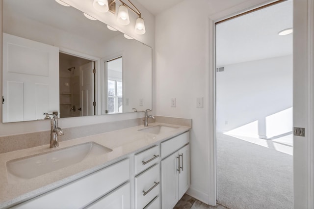 bathroom with double vanity, a shower, a sink, and visible vents