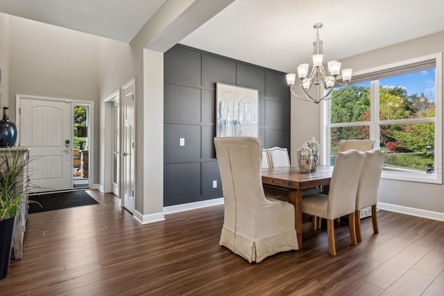 dining space featuring baseboards, dark wood finished floors, and a notable chandelier