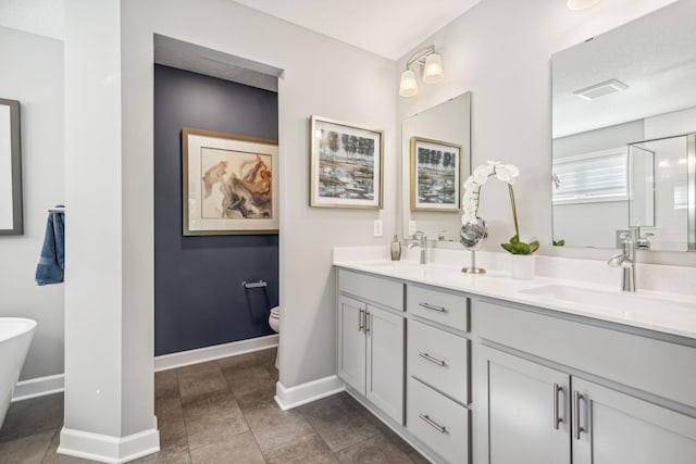 full bathroom featuring toilet, a sink, visible vents, baseboards, and double vanity