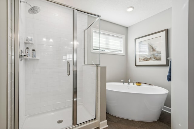 full bathroom with baseboards, a stall shower, a soaking tub, and tile patterned floors