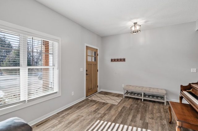 entrance foyer with visible vents, baseboards, and wood finished floors