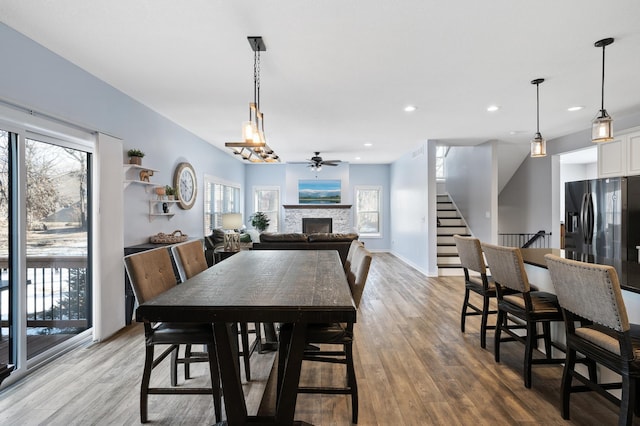 dining area with recessed lighting, stairway, a fireplace, and light wood-style floors