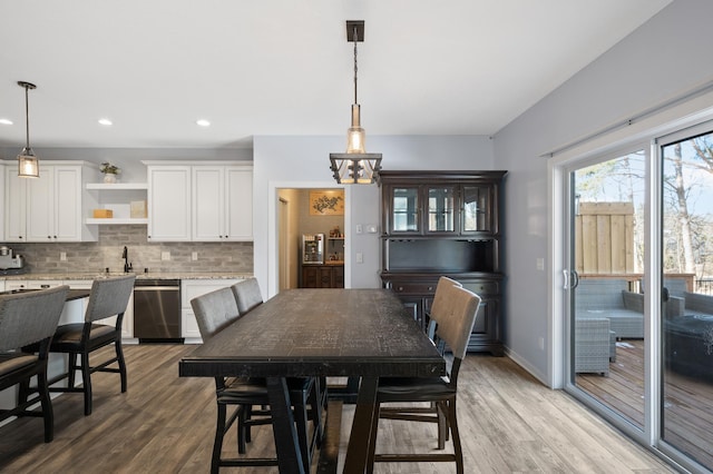 dining area with baseboards, light wood finished floors, and recessed lighting