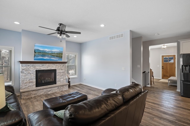 living area featuring a fireplace, visible vents, dark wood finished floors, and recessed lighting