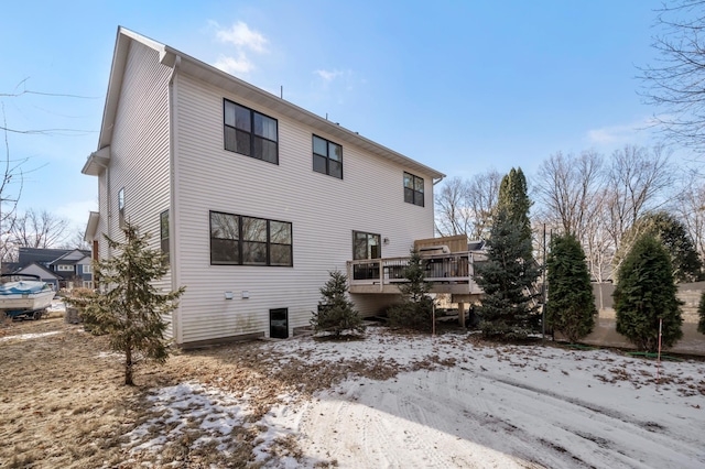 snow covered rear of property featuring a deck