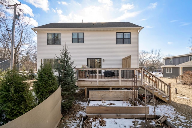 snow covered property featuring a deck and stairs