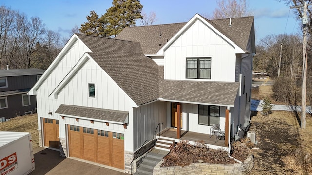 modern farmhouse with driveway, a shingled roof, a porch, and board and batten siding