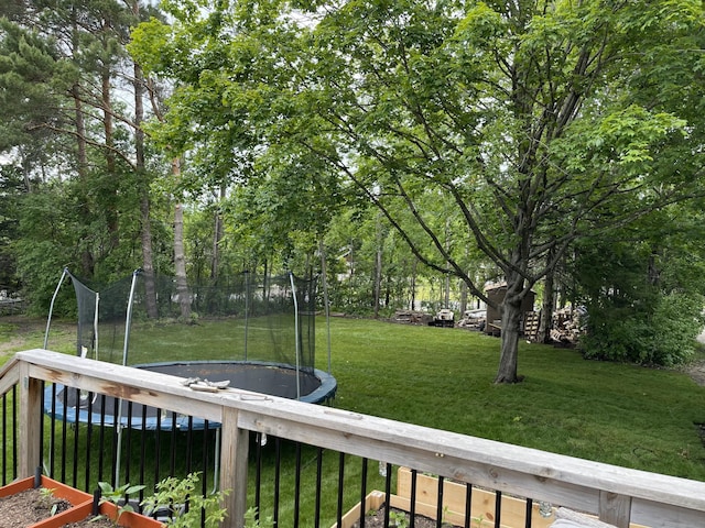 view of yard with a trampoline and fence