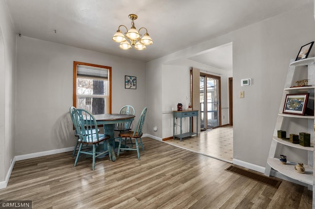 dining area with an inviting chandelier, baseboards, and wood finished floors