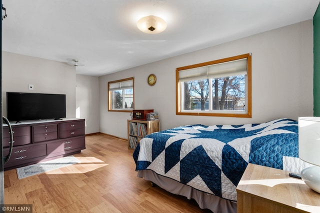 bedroom with light wood-style flooring and baseboards