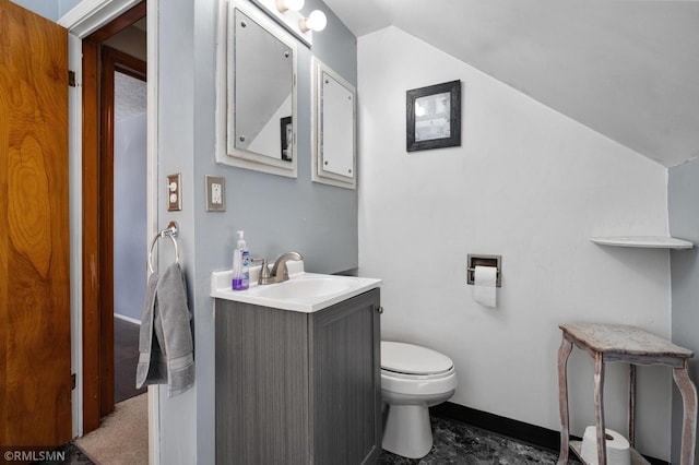 half bath with vaulted ceiling, vanity, and toilet