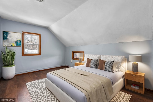 bedroom featuring lofted ceiling, baseboards, and hardwood / wood-style floors