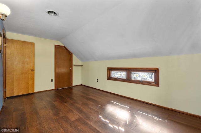 bonus room featuring vaulted ceiling, wood finished floors, visible vents, and baseboards