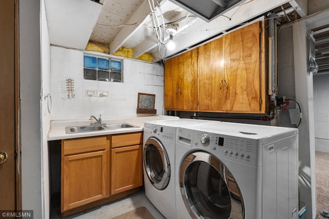 washroom featuring cabinet space, a sink, and washing machine and clothes dryer