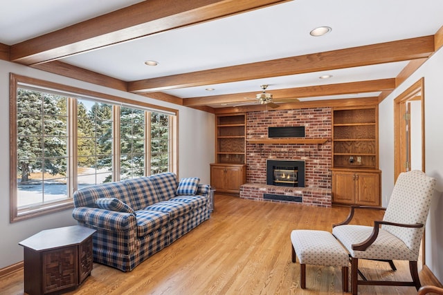 living area with beam ceiling, built in features, a fireplace, and light wood-style floors