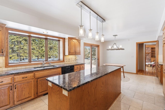 kitchen with a kitchen island, dishwasher, decorative backsplash, a notable chandelier, and a sink