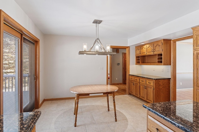 dining area featuring a chandelier, light tile patterned floors, and baseboards