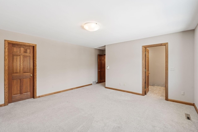 unfurnished room with visible vents, baseboards, and light carpet