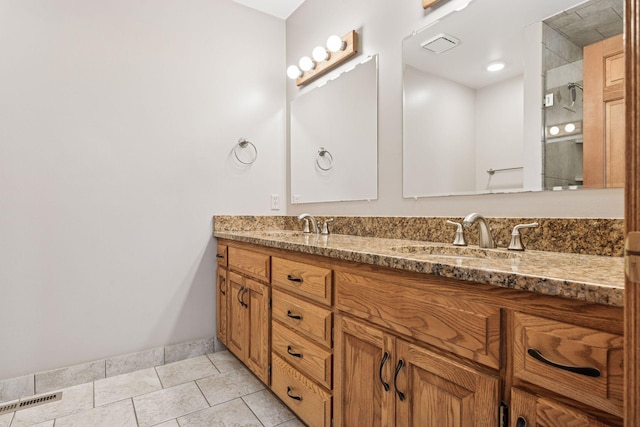 bathroom with baseboards, visible vents, double vanity, a sink, and tile patterned floors