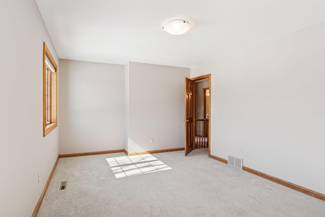 spare room with baseboards, visible vents, and carpet floors