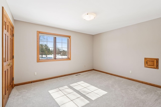 unfurnished room featuring visible vents, light colored carpet, and baseboards