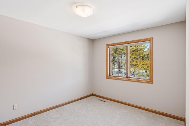 empty room with light carpet, visible vents, and baseboards