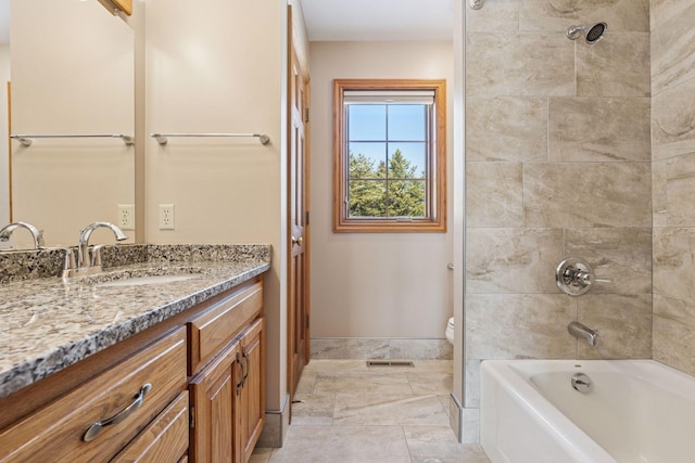 bathroom with visible vents, baseboards, washtub / shower combination, toilet, and vanity