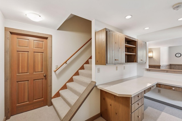 kitchen featuring open shelves, built in desk, recessed lighting, carpet flooring, and light countertops